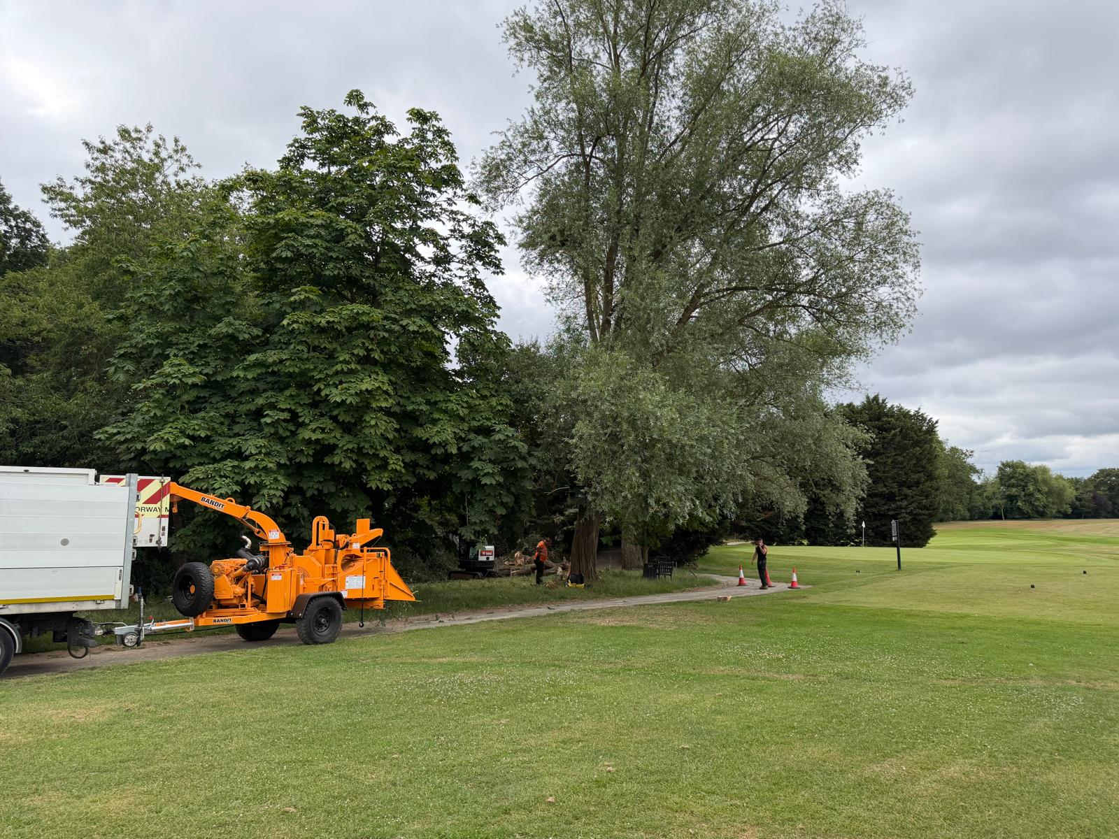 Tree surgery truck and woodchipper set up at a commercial parkland site